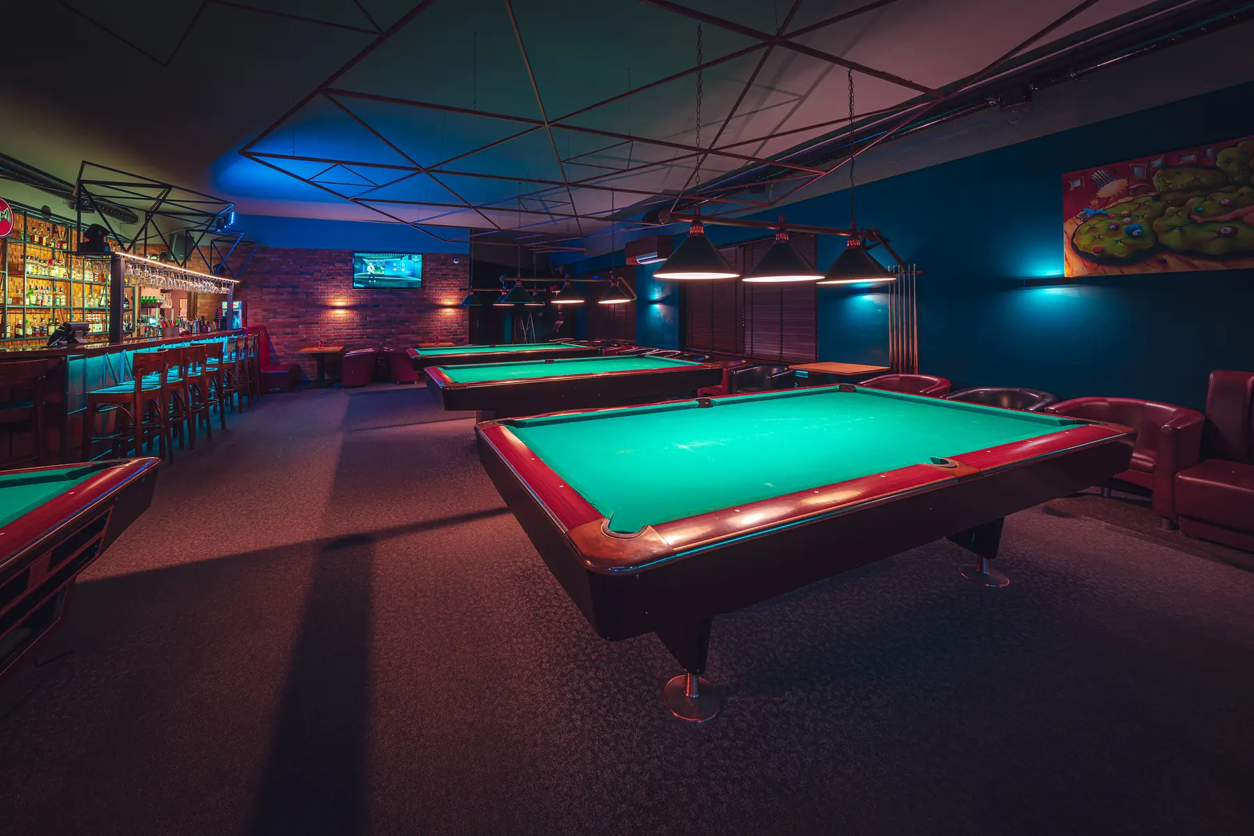 Sala Klubu Pictures ze stołami pool i ekranem na ceglanej ścianie