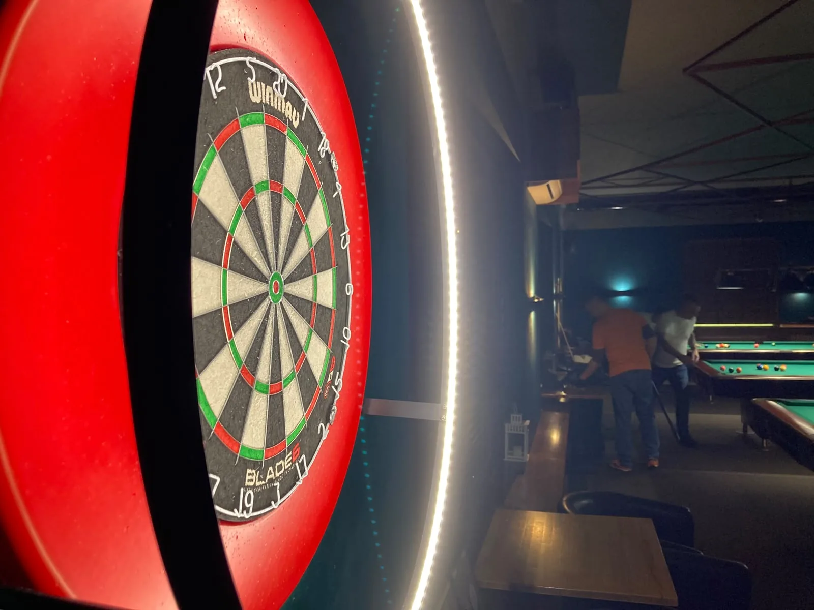 Tarcza do darta Winmau Blade 6 w Klubie Pictures, w tle stoły bilardowe
